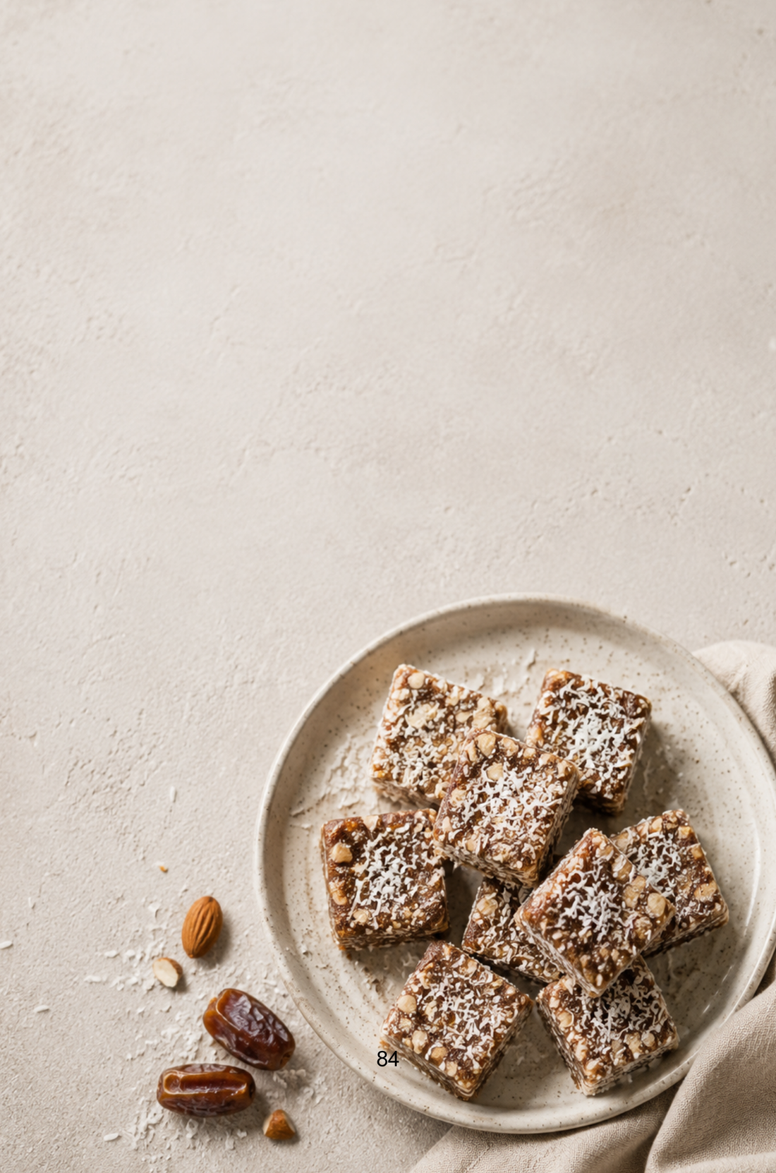 Coconut Date Squares made with dates, shredded coconut, almonds and cocoa powder.